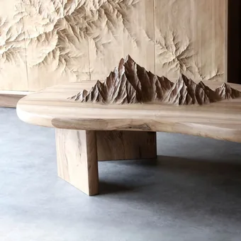 Wooden table with a carved mountain range rising from its top